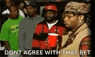 a group of men are standing in a line holding red cups and a man is holding a red cup .