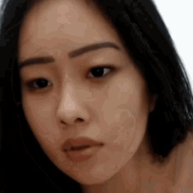 a close up of a woman 's face with black hair