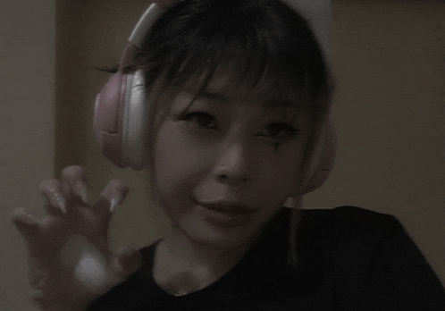 a girl wearing headphones and a black shirt is making a face