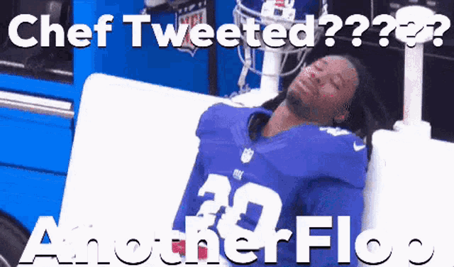 a man in a new york giants jersey laying on a couch