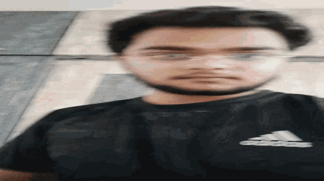 a man wearing glasses and an adidas shirt