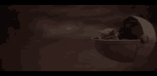a baby yoda is sitting in a stroller on a planet .