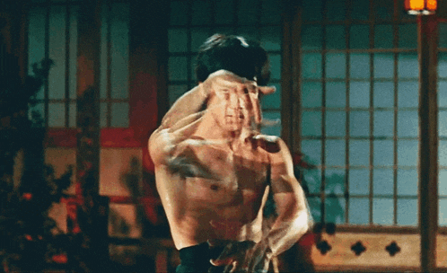 a man without a shirt is in a room with a window
