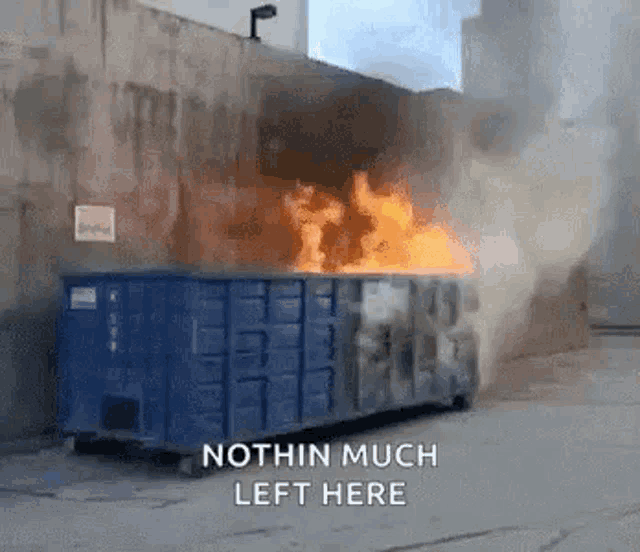 a dumpster is on fire with the words " nothin much left here " above it