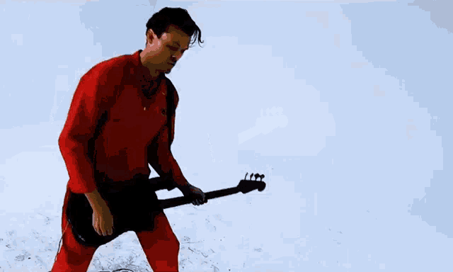 a man is wearing a red shirt and looking down at something .