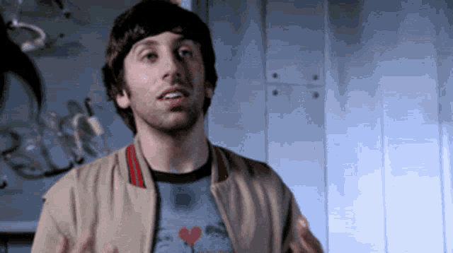 a man wearing a jacket and a shirt with a heart on it is making a funny face