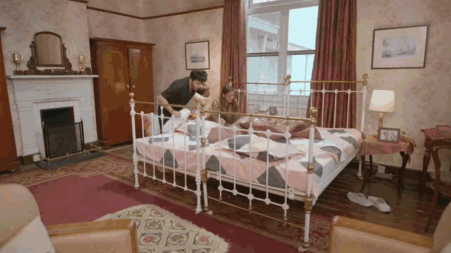 a couple laying on a bed in a room with a fireplace