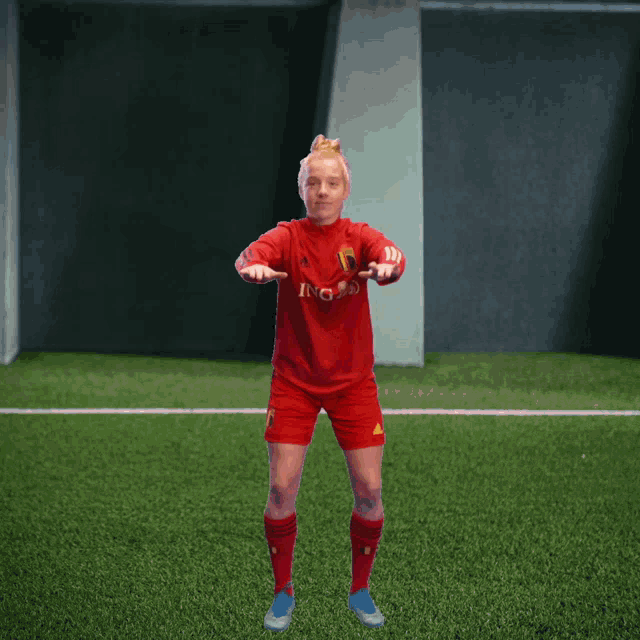 a female soccer player wearing a red jersey with ing on it
