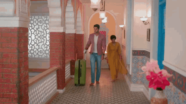 a man and a woman walking down a hallway with luggage