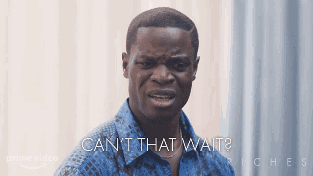 a man in a blue shirt says " can t that wait " in white letters