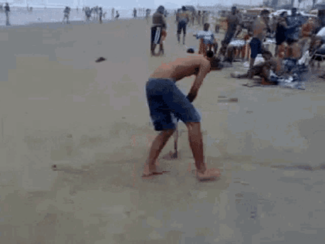 a man is digging in the sand with a shovel on the beach