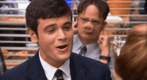 a man in a suit and tie is talking to a group of people