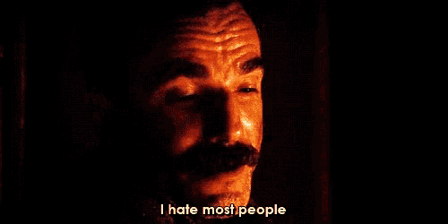 a man with a mustache says " i hate most people " in a dark room
