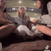 a group of people are sitting in a circle on a couch .