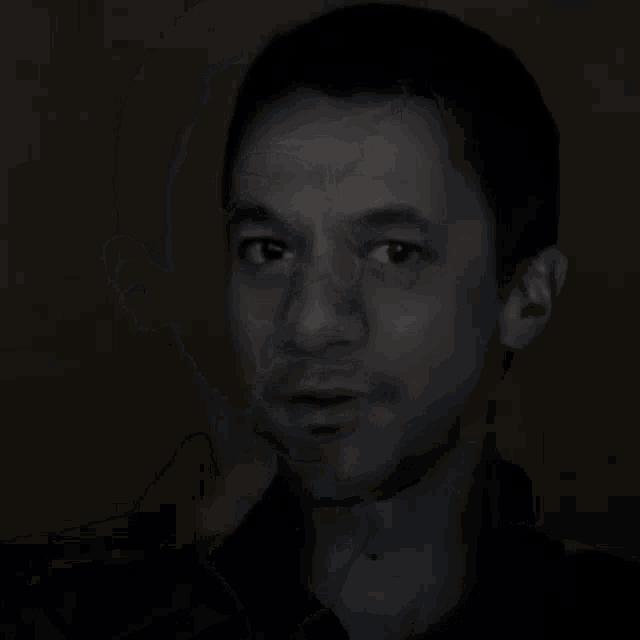 a close up of a man 's face in a black shirt
