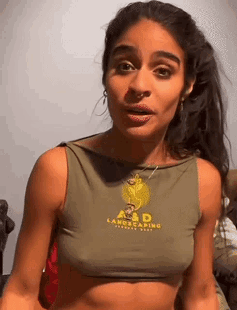 a woman is wearing a crop top that says a & d on it .