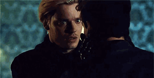two men are looking at each other in a room .