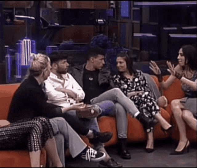 a group of people are sitting on a red couch
