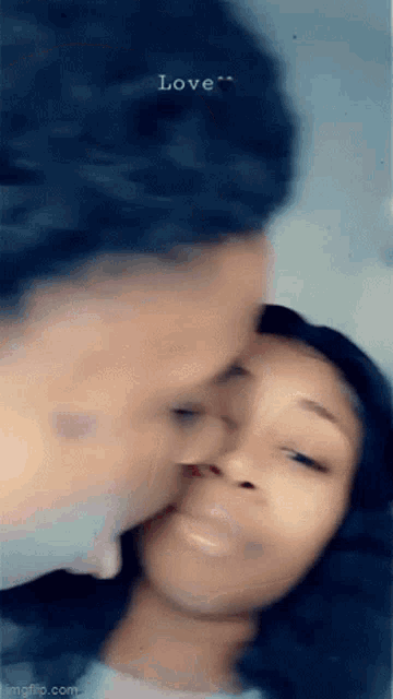 a man is kissing a woman on the forehead .