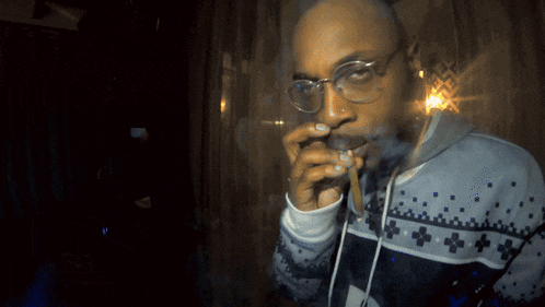 a man with glasses is smoking a cigarette