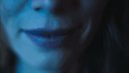 a close up of a woman 's mouth and teeth with a blue background