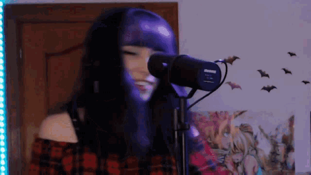 a girl with purple hair is singing into a shure microphone .