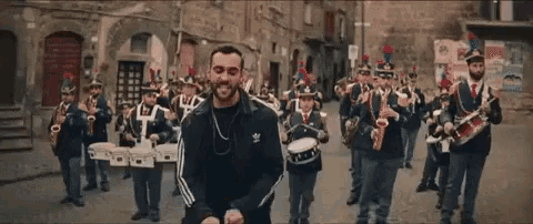 a man stands in front of a band playing instruments