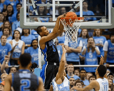 a basketball player with the number 5 on his jersey jumps to dunk the ball
