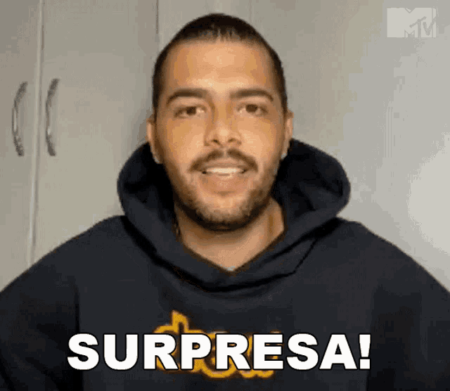 a man in a black hoodie says surprisesa in spanish
