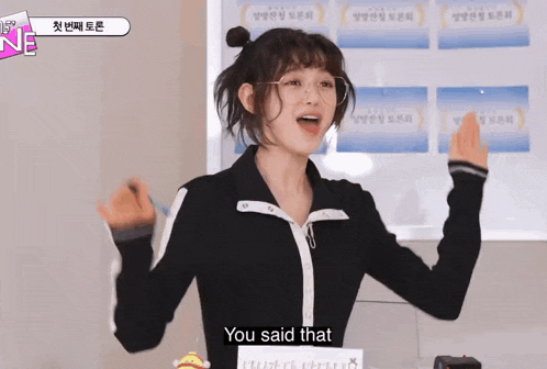 a woman in a black jacket is standing in front of a white board and says you said that