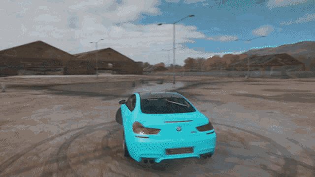 a blue car is driving through a dirt field