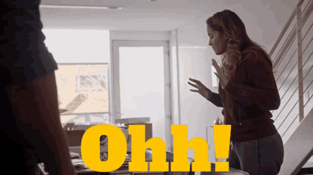 a woman in a red sweater stands next to a man with the word ohh in yellow