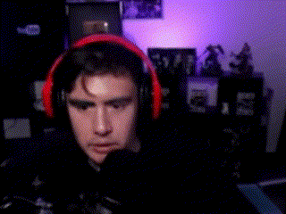a man wearing headphones is sitting in front of a computer in a room .