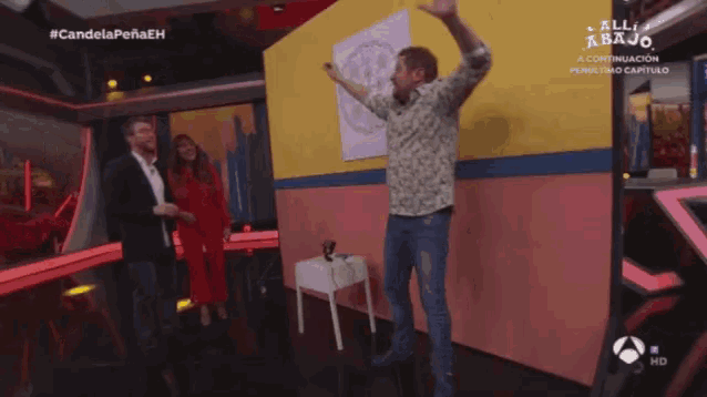a man is dancing in front of a wall that says all abajo on it