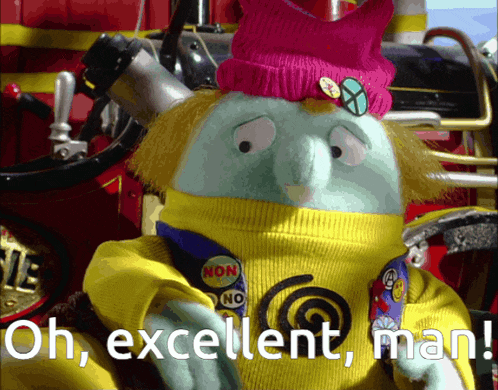 a stuffed animal with a yellow sweater and a pink hat says oh excellent man