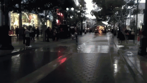 a blurry picture of people walking down a street in front of a store