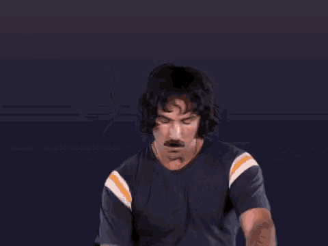 a man with a mustache is making a middle finger gesture .