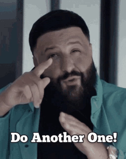 a man with a beard is pointing to his eye and says do another one