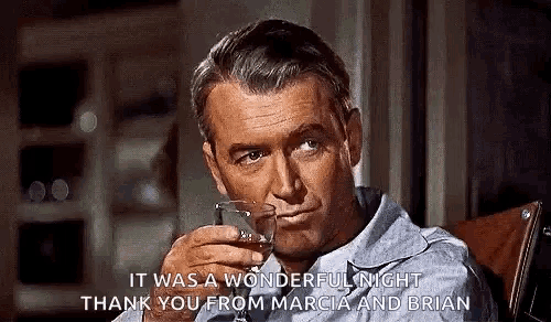 a man is holding a glass of whiskey in his hand .