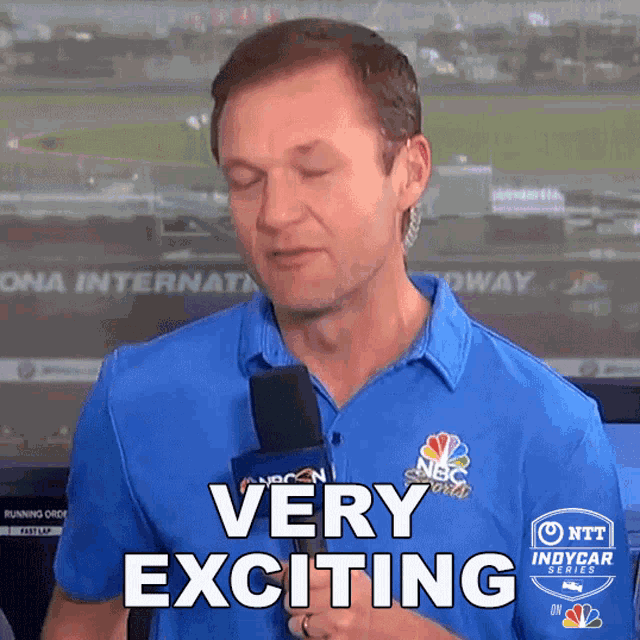 a man holding a microphone with the words very exciting on his shirt