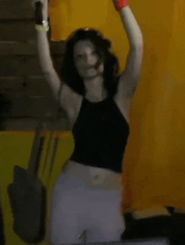 a woman in a black top is dancing in front of a man wearing a black shirt with a picture of a man