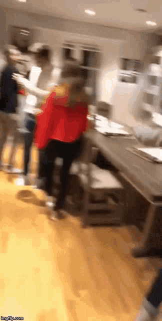 a blurry picture of a group of people standing around a table with a watermark that says imgflip.com