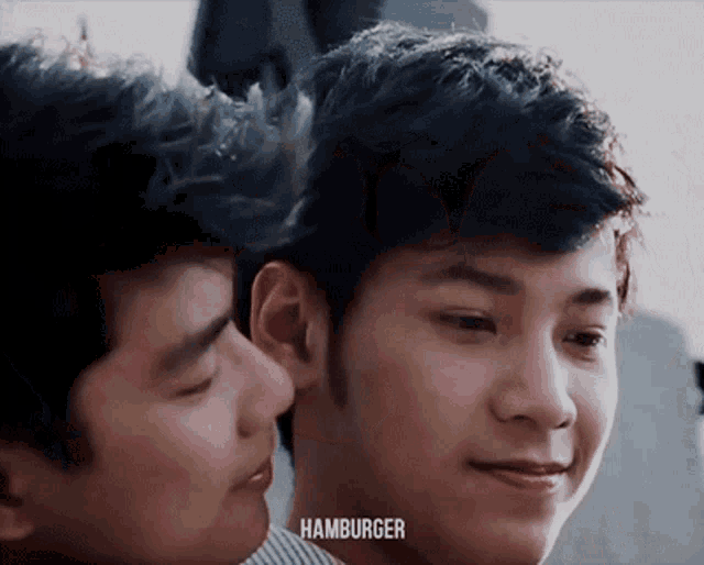 two young men are looking at each other and the word hamburger is on the bottom