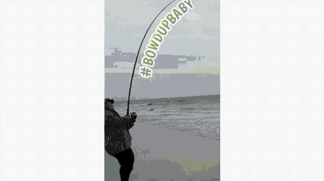 a person holding a fishing rod on a beach with the words #bowdupbaby written on it