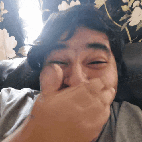 a man is covering his mouth with his hand