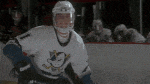 a hockey player wearing a white jersey with a duck on it