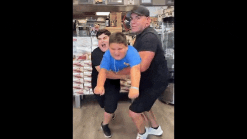 a man is holding a boy in his arms while a woman holds another boy .