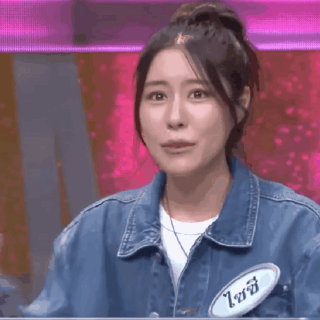 a woman wearing a denim jacket with a name tag that says ' ioi ' on it