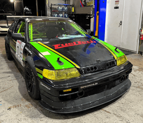 a green and black race car with fueltech on the hood