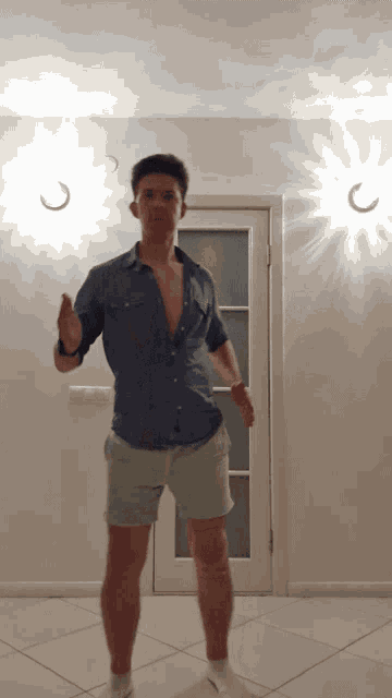 a man in a blue shirt and shorts is dancing in front of a door